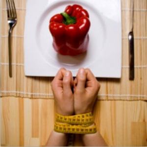 photo of two hands tied with a measuring tape and a plate with a bell pepper on it - freedom interventions - eating disorders
