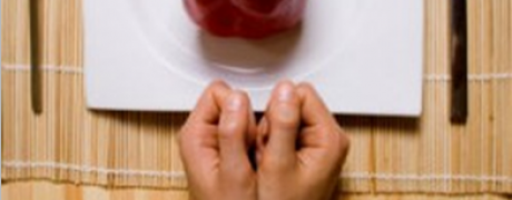 photo of two hands tied with a measuring tape in front of a plate with a bell pepper on it - Freedom Interventions - eating disorders
